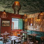Interior de restaurante em Tiradentes, com decoração rústica e paredes de pedra.