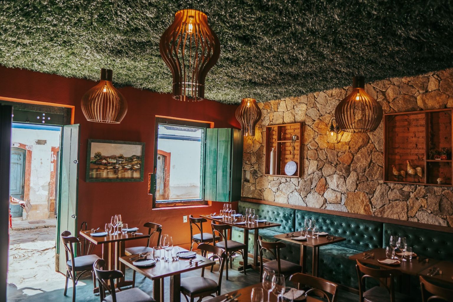 Interior de restaurante em Tiradentes, com decoração rústica e paredes de pedra.