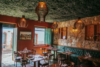 Interior de restaurante em Tiradentes, com decoração rústica e paredes de pedra.