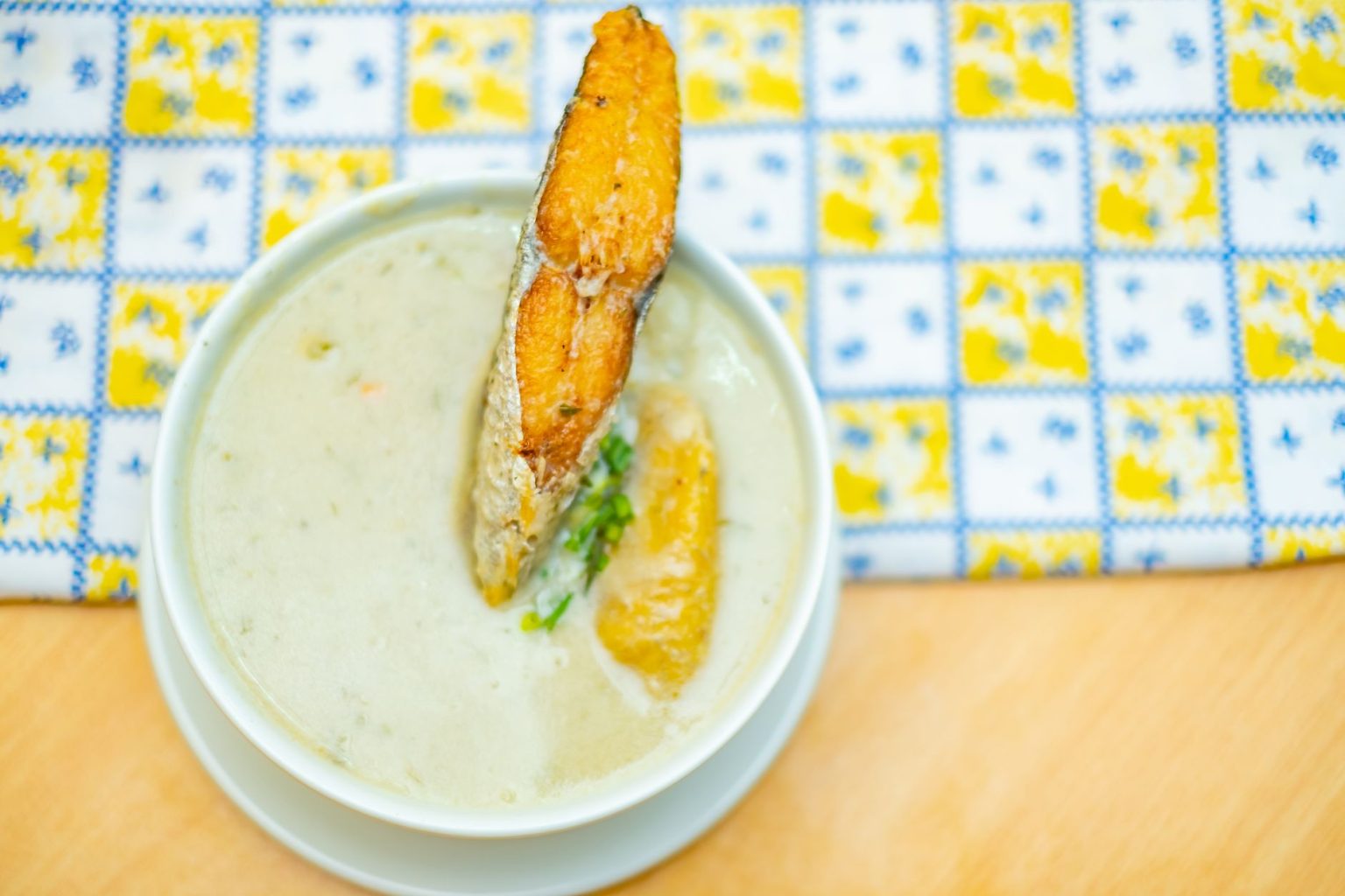 Prato cremoso de peixe com banana-da-terra servido em uma tigela.