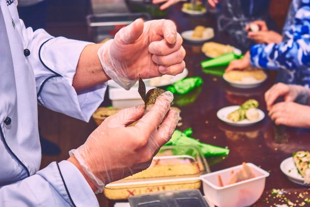 Chef demonstra o preparo de um aperitivo durante uma aula de culinária.